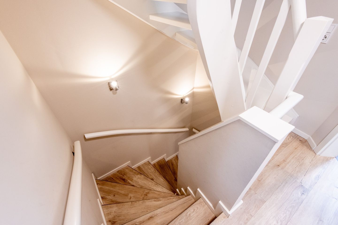 A spiral staircase with wooden steps and white railings.