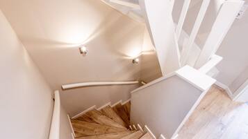 A spiral staircase with wooden steps and white railings.