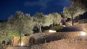A stone wall with a stone staircase leading up to a building.