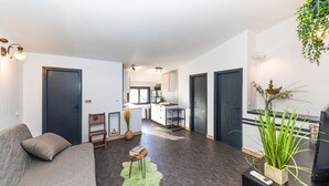 Apartamento moderno com sala de estar, cozinha compacta e área de jantar.