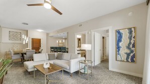 A spacious living room with a modern sofa, a wooden coffee table, and a dining area with a table and chairs. - Origin 1308 | Gulf-View Condo w/ Balcony & Full Kitchen! (Panama City Beach)