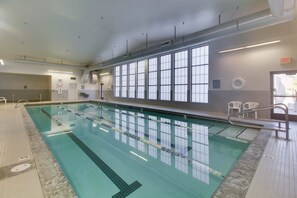 An indoor swimming pool with clear lanes, a tiled floor, and a large window with multiple panes. - Double Take Condo - Aspen Village - Golf - Shared Pool, Hot tub, Sauna, Gym, Courts (McCall)
