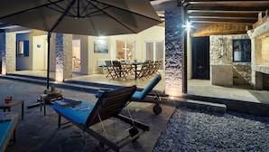 An outdoor seating area with a table, chairs, and a large umbrella. - Augusta by Interhome (Rovinj/Žminj)