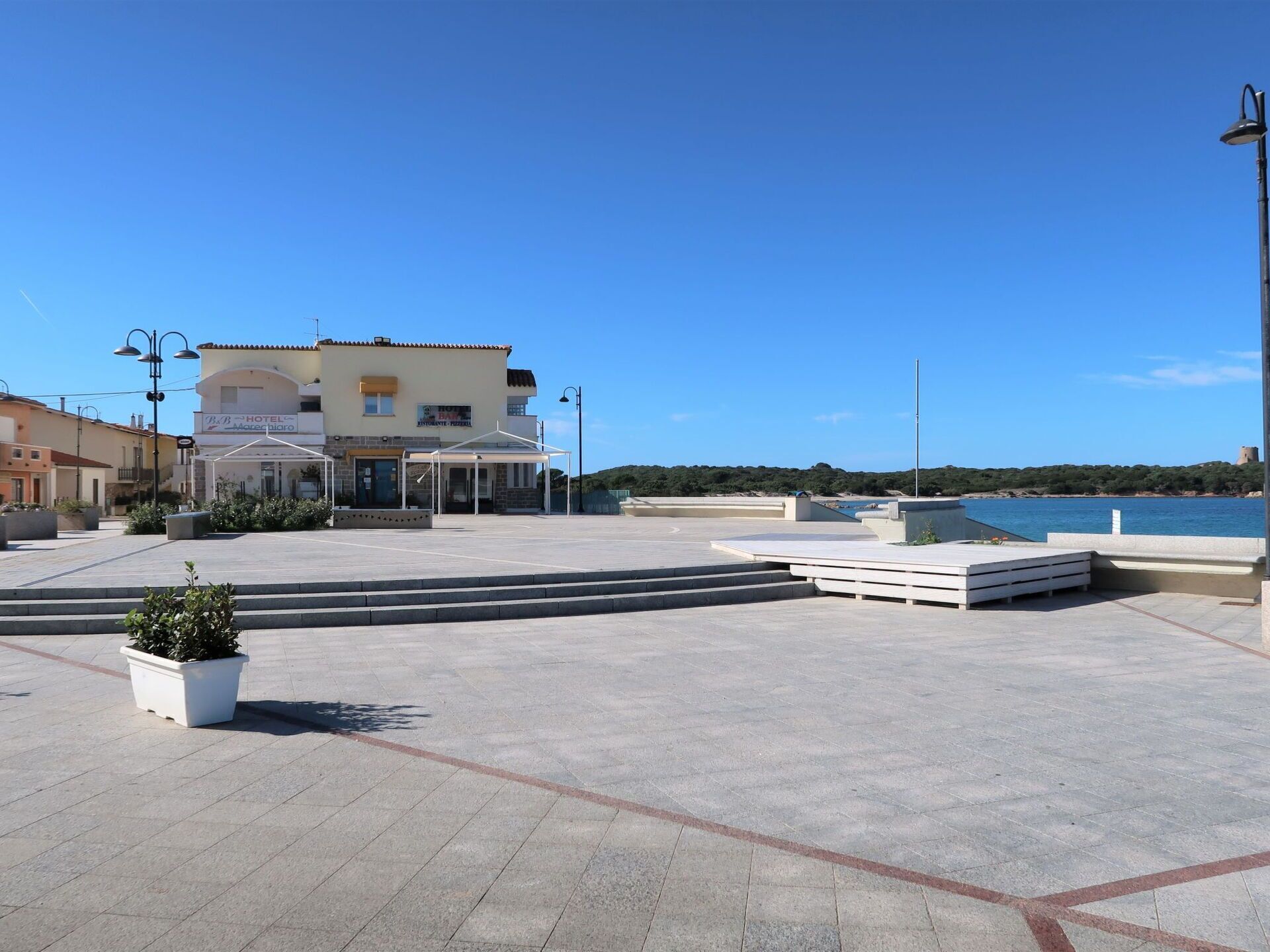 Un hôtel doté d’une terrasse, de sièges en plein air et offrant une vue sur la mer.