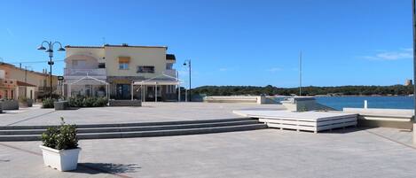 Un hôtel doté d’une terrasse, de sièges en plein air et offrant une vue sur la mer.