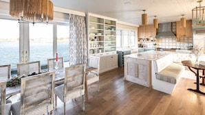 A spacious kitchen with a large island, wooden cabinets, and a view of the water. - Luxury oceanfront 5 bedroom, 5.5 bath private dock overlooking Mothers Beach! (Kennebunk)