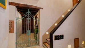 A staircase with a wooden handrail and a green wrought iron gate leading to a room. - Luxury 5BR House W Jacuzzi & Pool (Cartagena)