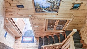 A wooden cabin interior with a staircase, a 'NO SMOKING' sign, and a painting of a mountain landscape. - Awesome home in Lovinac (Lovinac)
