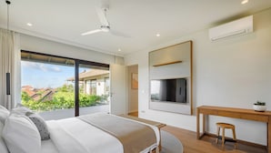 A modern bedroom with a bed, a desk, and a TV.