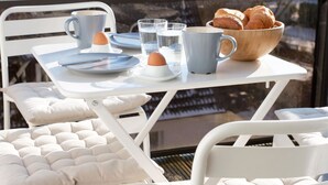 A breakfast setup with a table, chairs, and a view through a window.