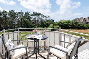 Un espace extérieur abrité, aménagé avec une table, des chaises et un livre.