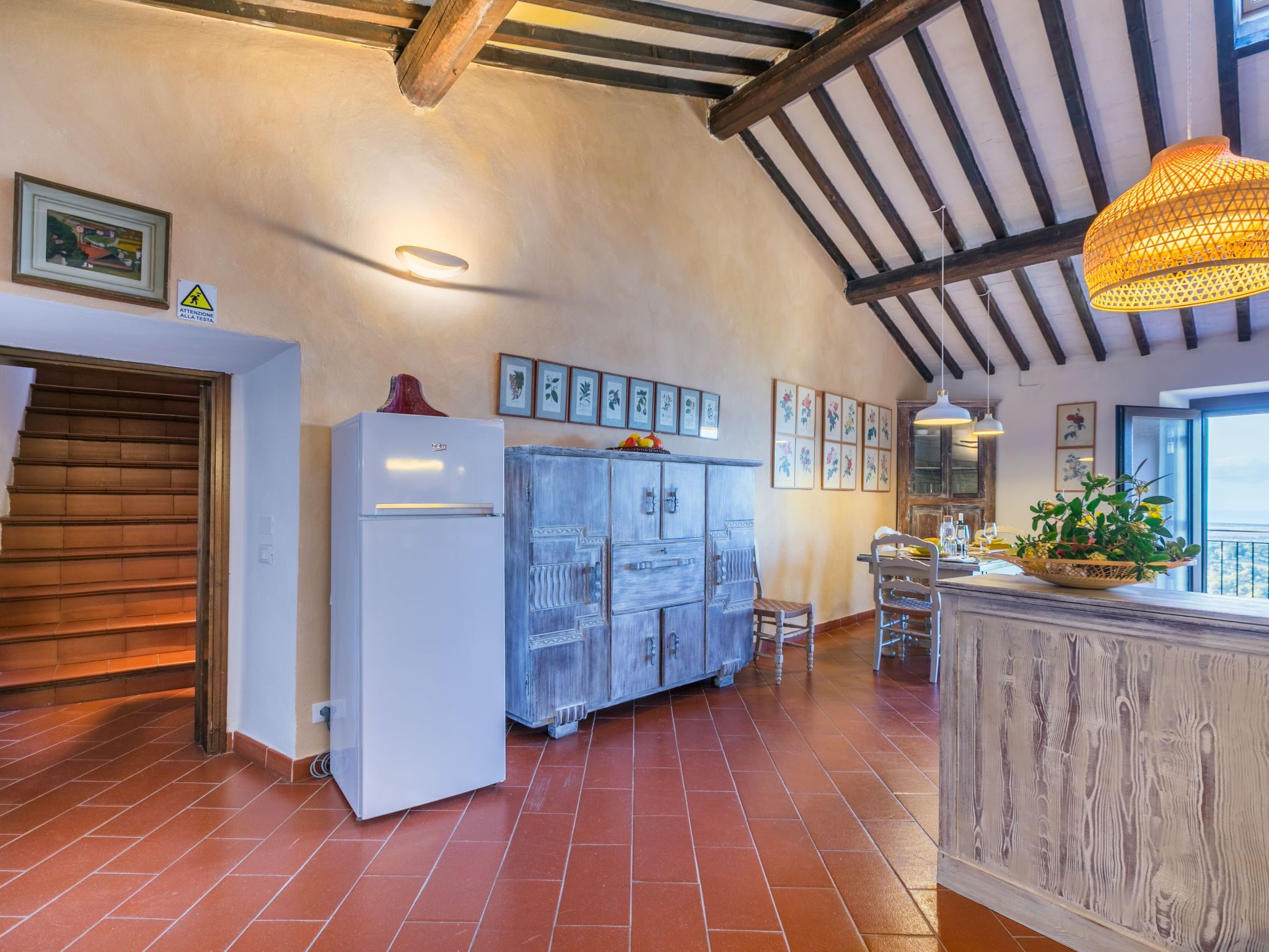 A kitchen with a white refrigerator, wooden cabinets, and a dining area with a table and chairs.