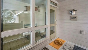 Eine Veranda mit Holzgeländer, Fußmatte und Briefkasten.
