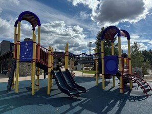Un parque infantil con un tobogán y estructuras para escalar.
