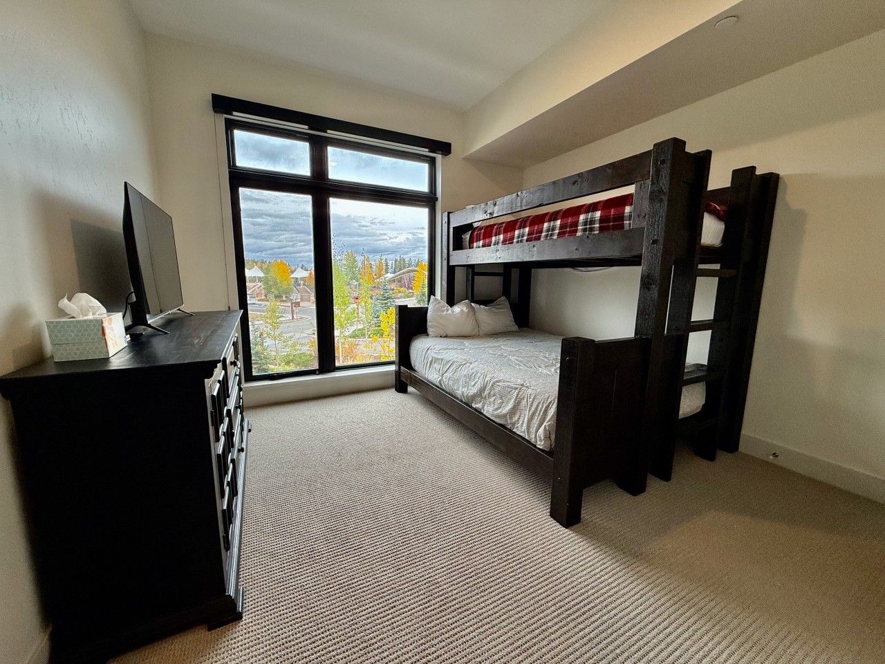 Ein Schlafzimmer mit Etagenbett, Schreibtisch mit Computer und Fenster mit Blick.