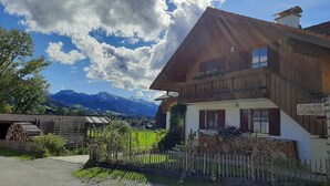 A two-story wooden house with a sign indicating it's a rental property. - Apartment "Mair - Sonnaufgang" with Mountain View, Shared Terrace & Wi-Fi (Halblech)