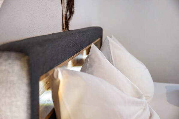 A bed with a wooden headboard and white pillows.