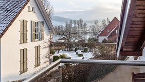 A residential area with a view of a lake, houses with shutters, and a bench in the foreground. - Apartment 'Gertrud' with Lake View, Balcony and Wi-Fi (Öhningen)