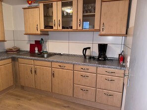 Een koelkast, een oven, een kookplaat, een koffiezetapparaat/waterkoker