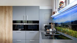 A modern kitchen with built-in appliances, a countertop with a sink, and a decorative fish tank.