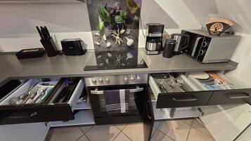 Une cuisine moderne équipée d’un four encastré, d’une machine à café et d’un grille-pain.