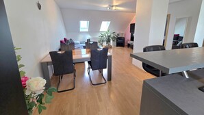 A modern interior with a dining area, a sofa, a TV, and a plant. - Holiday Apartment "Lampl Haus" with Wi-Fi (Steindorf)