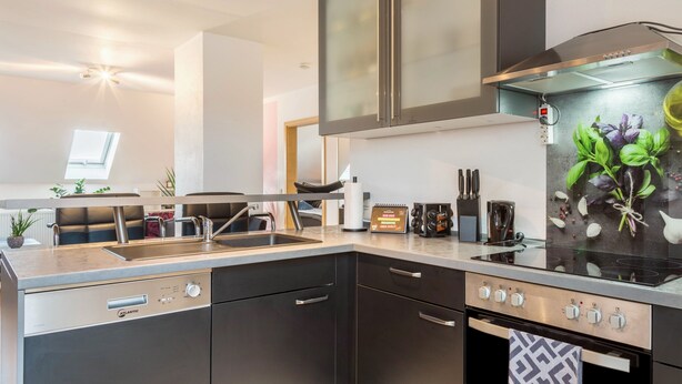 A modern kitchen with a built-in stove, a sink, and a microwave. - Holiday Apartment "Lampl Haus" with Wi-Fi (Steindorf)