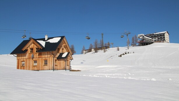 A wooden lodge with a ski lift in the background.