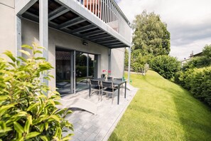 A modern house with a patio, a dining area, and a covered outdoor space.