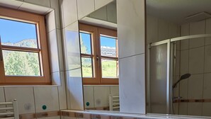 Un baño con dos lavabos, un espejo y una ventana.