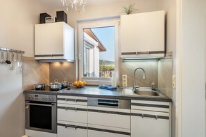 Fridge, microwave, oven, stovetop - Holiday Home 'Ferienhaus Am See mit Boot' with Private Terrace, Wi-Fi and Air Conditioning (Mustin)