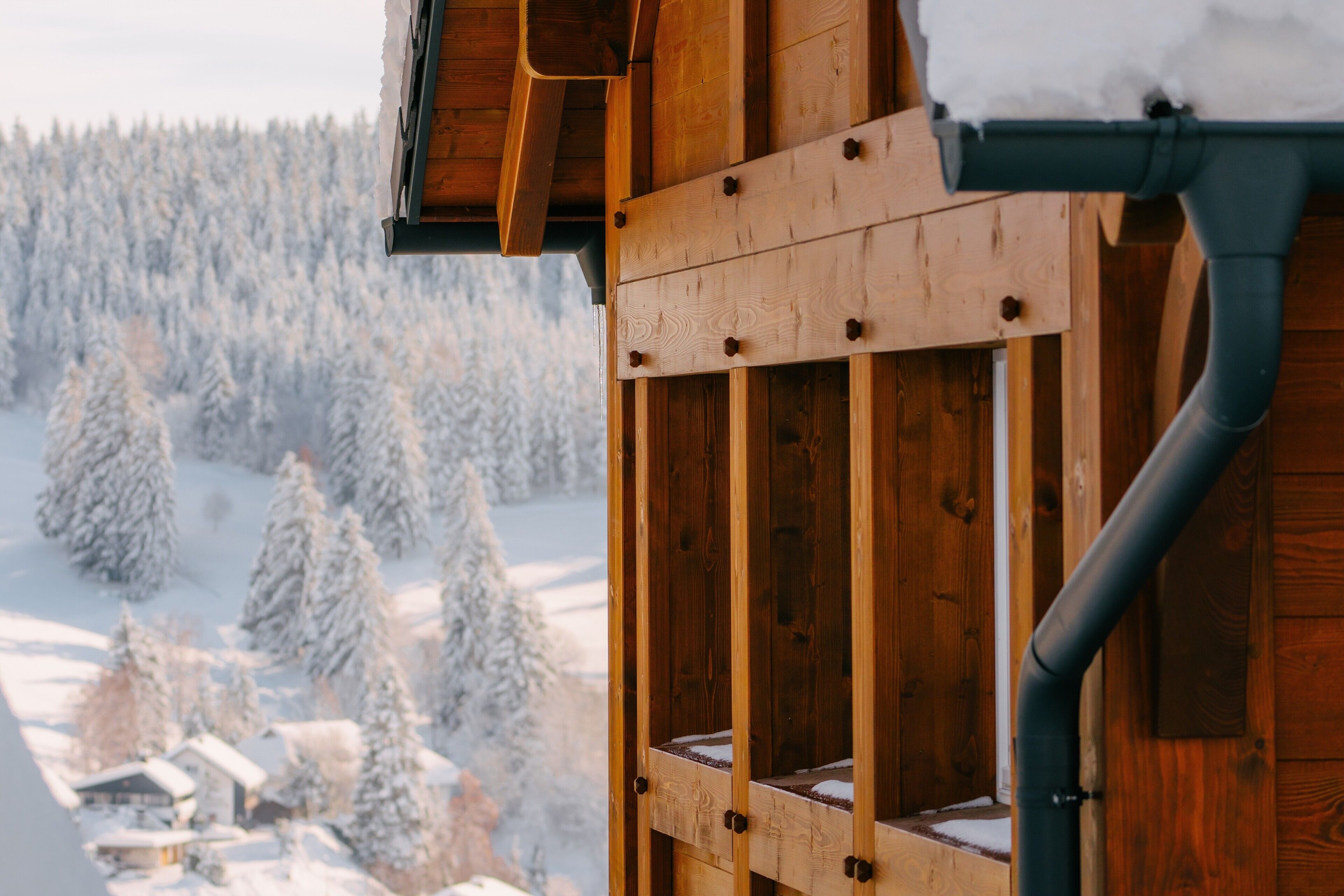 Eine Holzkonstruktion mit Fenster und Metallrohr.