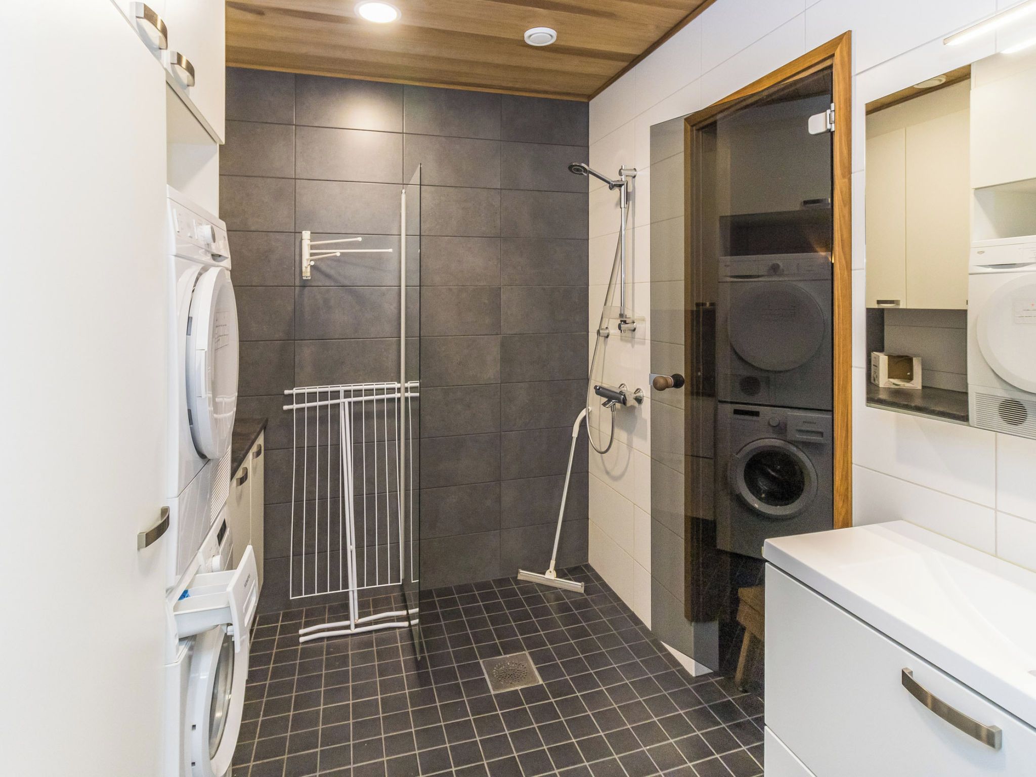 Ein modernes Badezimmer mit Dusche, Waschmaschine und Trockner.