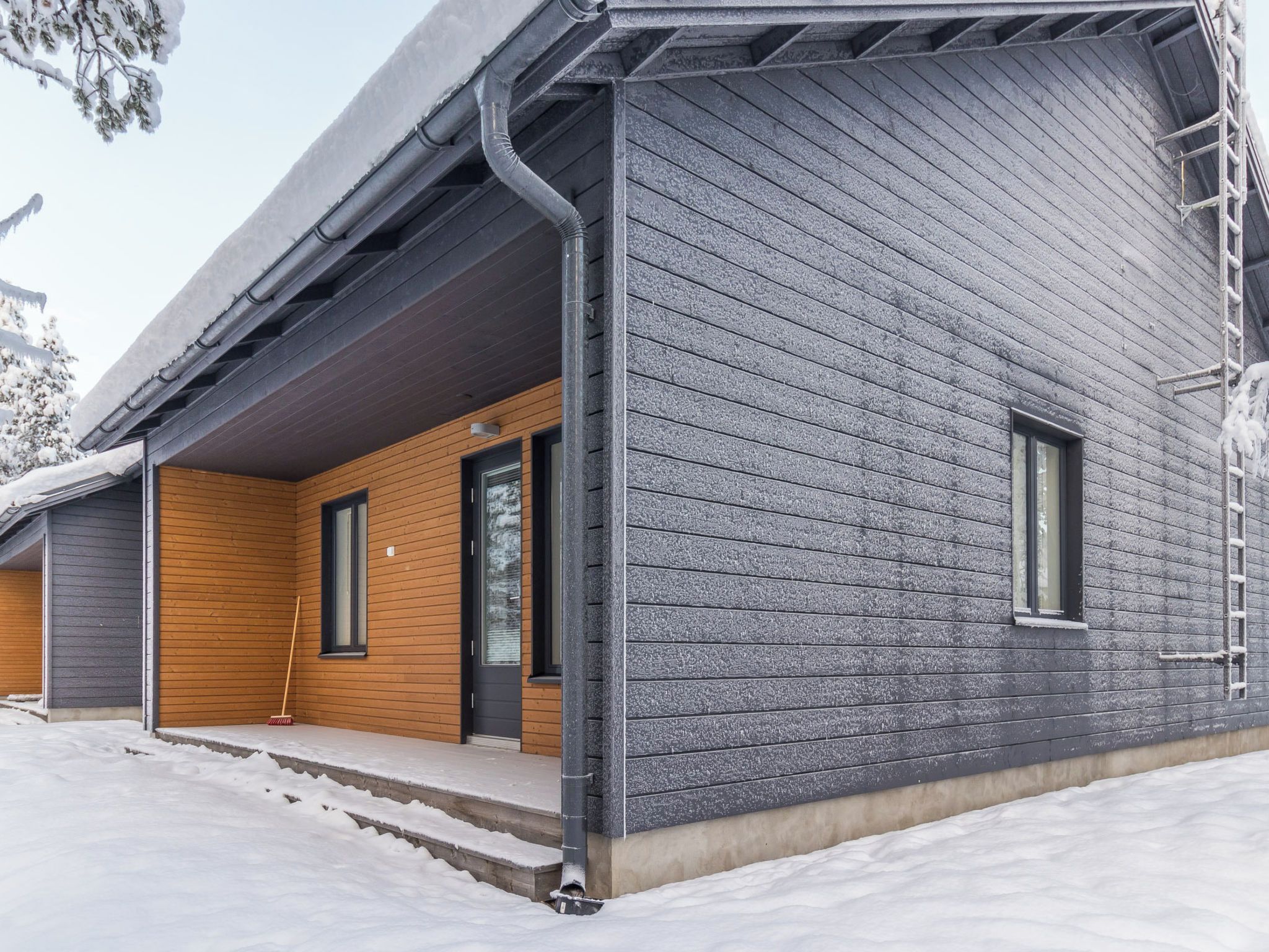 Un bâtiment moderne à l’extérieur gris, agrémenté d’éléments en bois.