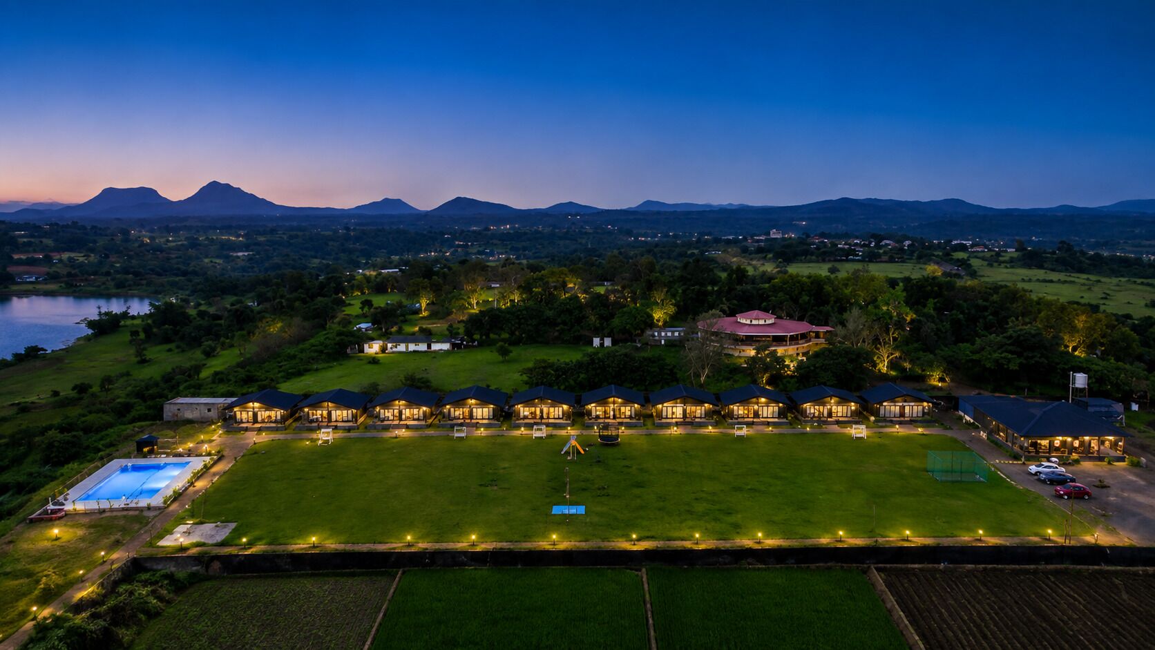 A hotel with multiple guest rooms, a swimming pool, and a tennis court.