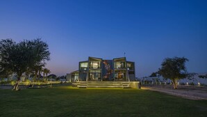 Un edificio moderno de dos pisos con ventanas amplias y un diseño de fachada singular.
