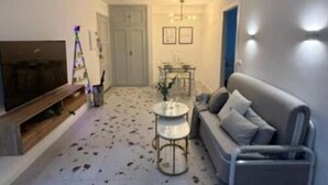 Ein Wohnzimmer mit Fernseher, Sofa und Couchtisch.