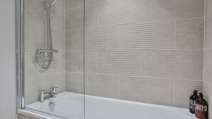 A modern bathroom with a glass-enclosed shower, a white bathtub, and a tiled wall. - 2 Bedroom Self-Contained Flat - 2 beds, 2 baths (Sheffield)