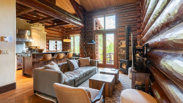 L’intérieur d’une cabane en rondins comprend un espace de vie, une cuisine et une cheminée.