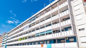 A multi-story hotel with balconies, air conditioning units, and a clear blue sky. - Apartment near the centre of Caorle (Caorle (VE))