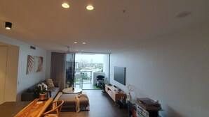A modern living room with a sofa, coffee table, and TV. - New apartment, spectacular views day and night. Close to everything!! (Surfers Paradise)