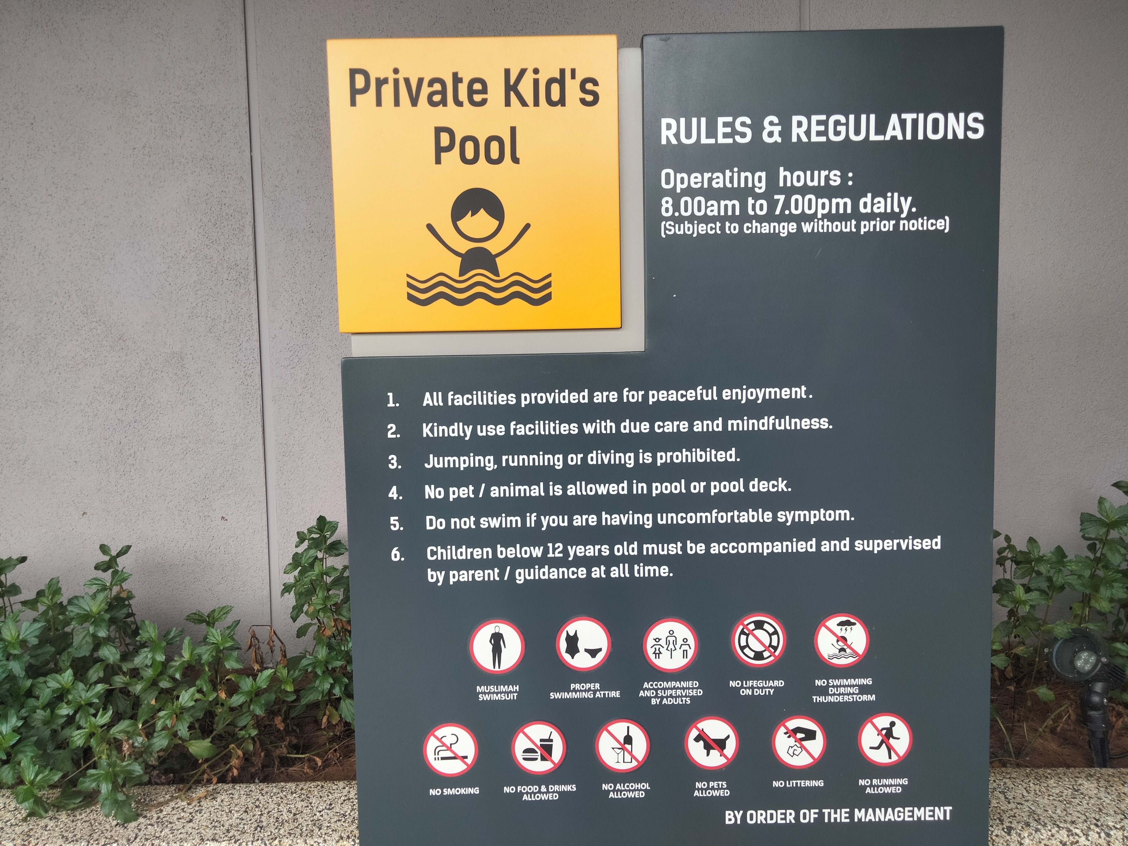A sign for a private kid's pool with rules and regulations, including operating hours and a list of prohibitions.