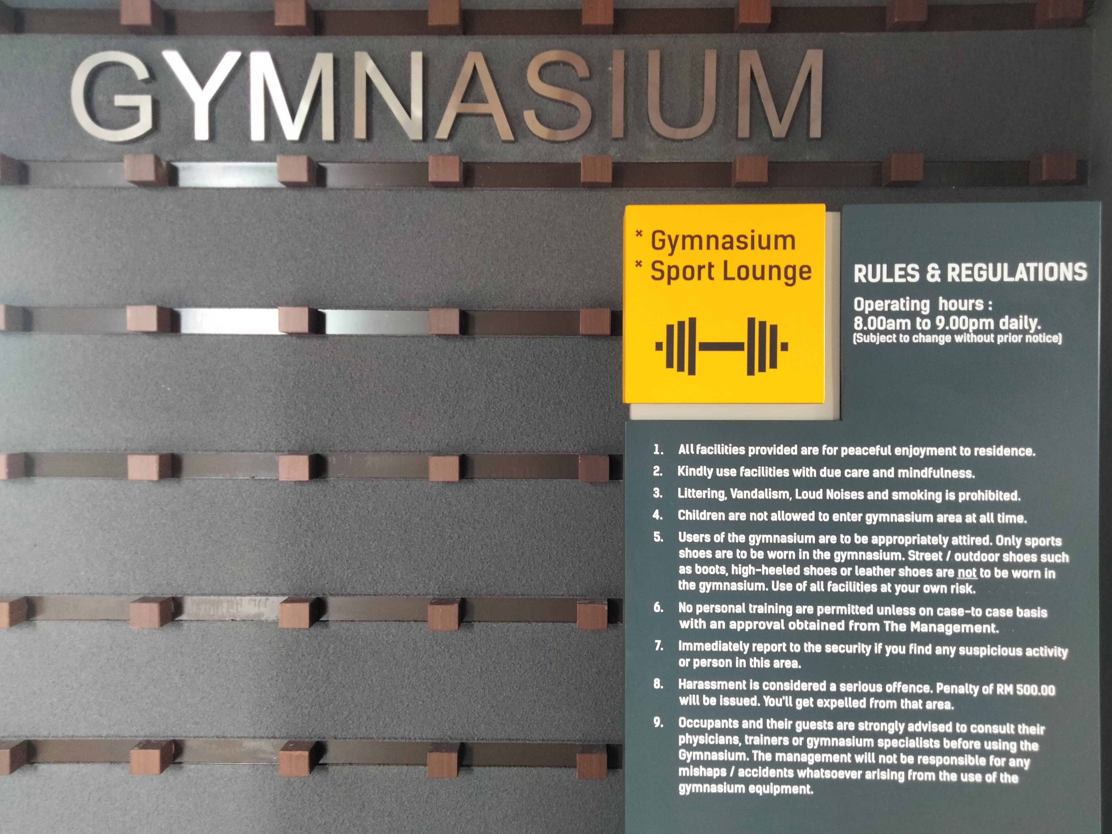 Placa indicando uma academia e espaço de lazer esportivo, com regras e regulamentos listados.
