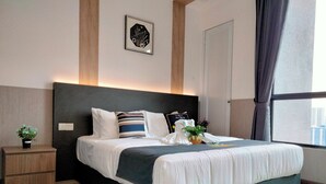 A modern hotel room with a large bed, a nightstand, a potted plant, and a view of the city through the window. - Cubic Botanical Suites HomeBrickz (Kuala Lumpur)