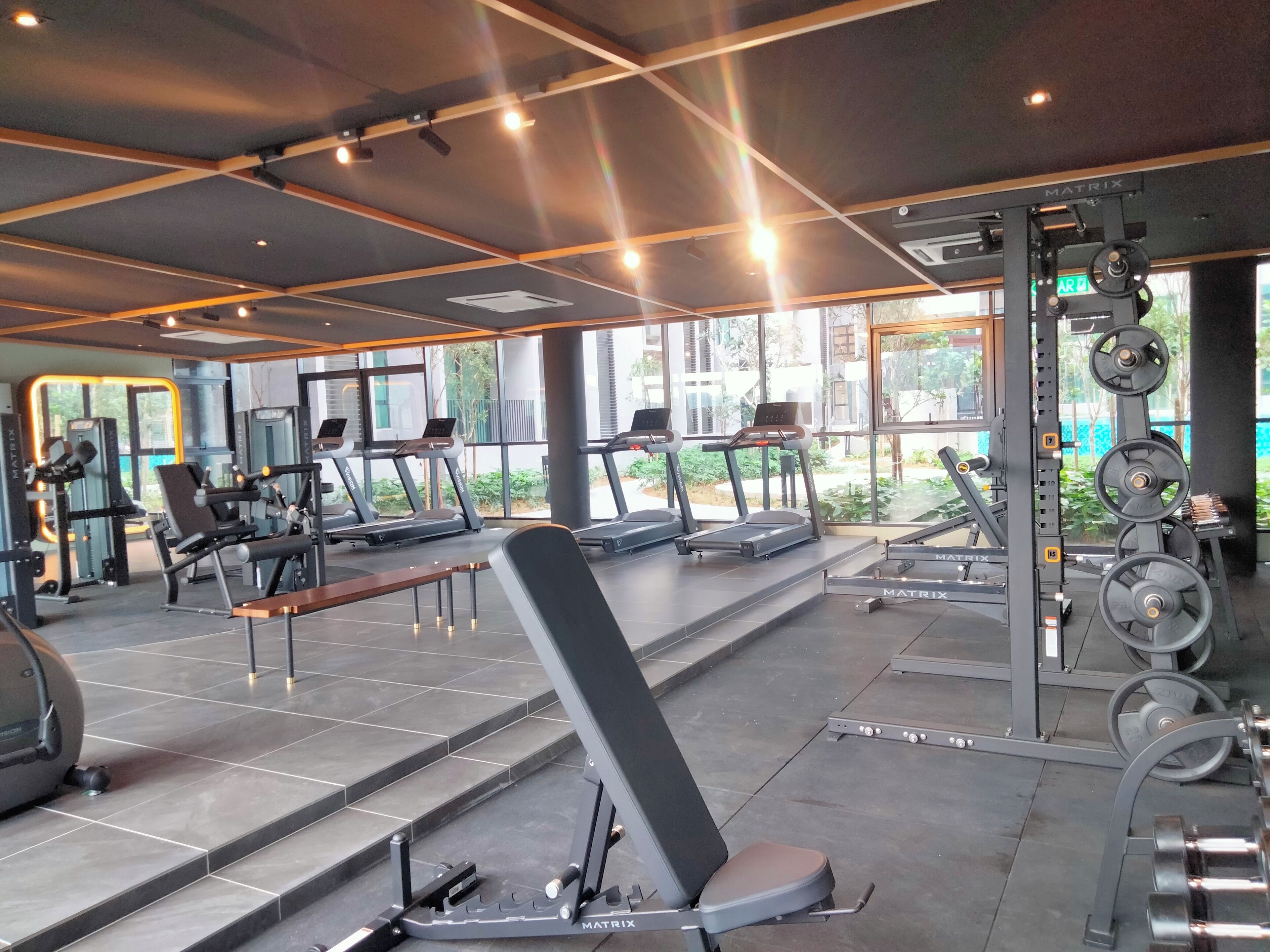 A gym with treadmills, weight machines, and a bench.