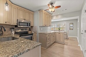 A kitchen with granite countertops, stainless steel appliances, and wooden cabinets.