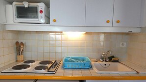 Et køkken med mikroovn, komfur, vask og opvaskemaskine.