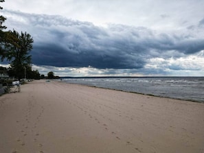 A beach with a sandy shore, a few footprints, and a cloudy sky. - Historic Oneida Lakefront Home 14/BR Sleeps 42! (Blossvale)