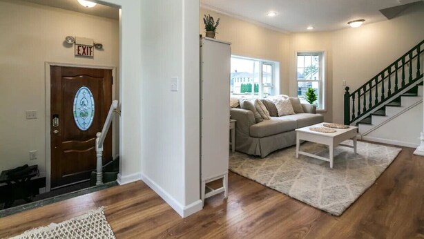 Un salon avec un canapé, une table basse et un escalier.