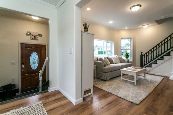 A living room with a sofa, coffee table, and a staircase.